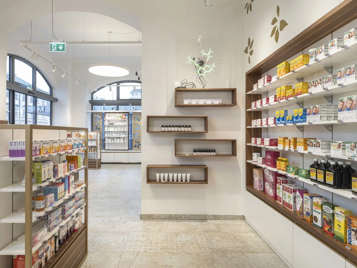 Beratungsbereich der Salvator Apotheke mit Regalwand, Wandnischen und Rundbogenfenster zum Mirabellplatz