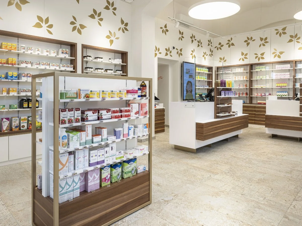 Verkaufsraum der Salvator Apotheke mit Freiwahl-Regal, Beratungstischen und beleuchteter Deckenkuppel